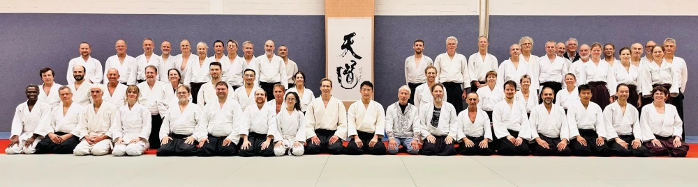 Gruppenfoto vom Aikido Herbstlehrgang 2025 in Berlin Steglitz mit Shimizu Kenta Wakasensei Gruppenfoto mit Teilnehmern des Lehrgangs aufgenommen auf der Tatami am letzten Trainingstag
