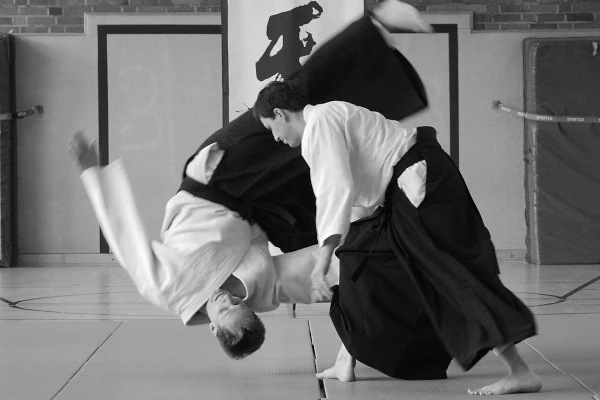 Foto, das eine Aikido-Technik mit tobi ukemi, dem freuen Fall zeigt